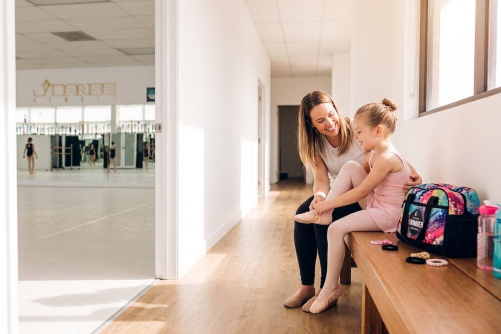 Mother helping daughter put on ballet slippers before her first dance class at J'Danse Studio in Scarborough Toronto