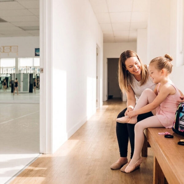 Mother helping daughter put on ballet slippers before her first dance class at J'Danse Studio in Scarborough Toronto
